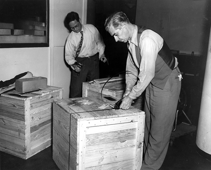 A photograph of two men preparing wooden crates. © FAO photo.