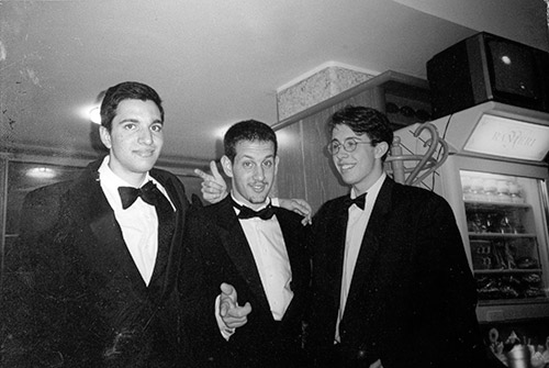 A photo showing Jimmy, Charlie and Frankie dressed in tuxedos in a restaurant for a PROM PARTY at night.