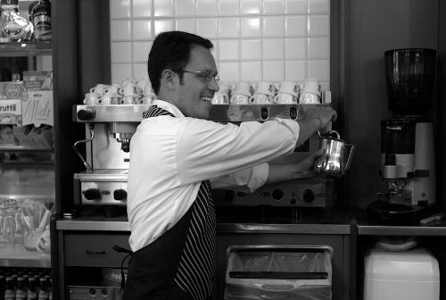 A picture of Carlos working with the coffee machine in the bar.